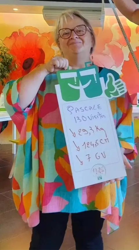Souriante, une membre désigne les chiffres de son bilan, inscrits sur l’ardoise
